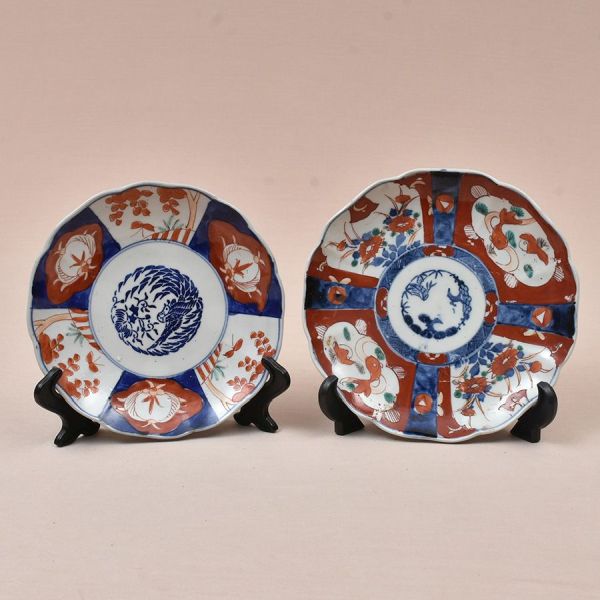 Dois pratos em porcelana Imari japonesa, de formato lobado, decorados em policromia sob e sobre o esmalte, nas tradicionais tonalidades azul-cobalto e vermelho-ferroso, com delicados detalhes em verde
