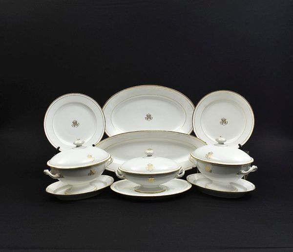 Aparelho de jantar de porcelana francesa na cor branca com monograma `M` em dourado e frisos na borda no mesmo tom. Composto de 39 pratos rasos (2 com bicadinho), 20 fundos (7 com bicadinhos), 36 de s