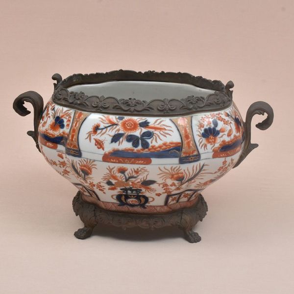 Centro de mesa (jardinière) em porcelana chinesa no padrão Imari, com montagem em bronze patinado. O corpo, de forma ovoide apresenta decoração polícroma em paleta típica Imari — rouge de fer, azul-co
