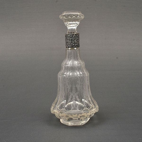 Garrafa licoreira europeia em cristal lapidado e gravado, com corpo facetado de formato campanular, ricamente decorado com motivos florais e folhagens. Apresenta elegante gargalo octogonal com colar e