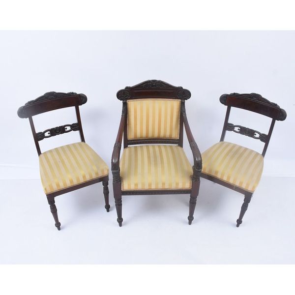 Conjunto de três cadeiras estilo Regência, sendo uma poltrona e um par de cadeiras. Espaldares das cadeiras recortados com entalhes de concha e folhagem, pernas dianteiras torneadas e estriadas; na po