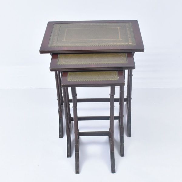 Mesa ninho. Conjunto de três mesas nesting em madeira nobre entalhada, com pernas em fuste tipo bambu no estilo inglês vitoriano/eduardiano. Tampos retangulares com friso de couro verde gravado, decor