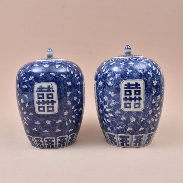 Par de potiches em porcelana chinesa azul e branca do sec. XIX, corpo ovoide com tampa e remate em botão, decorados com ramos de flor-de-ameixeira (mei) em reserva branca sobre fundo azul-cobalto . Ao