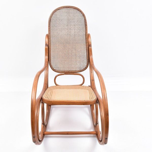 Cadeira de balanço em madeira curvada (bentwood), no estilo Thonet, com estrutura em volutas contínuas formando os balancins e os braços em curva única. Assento e encosto em palhinha trançada, encosto
