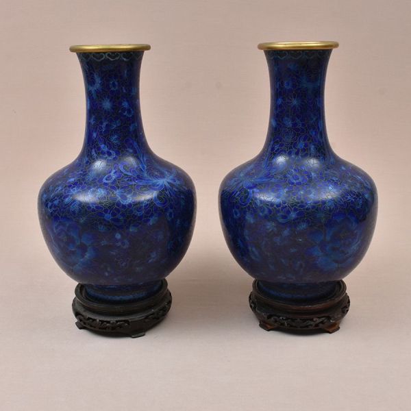 Par de vasos chineses em bronze com esmalte cloisonné em tons predominantes de azul-cobalto e azul-royal, corpo bulboso, gargalo alto afunilado com boca reta guarnecida por friso dourado. Decoração em