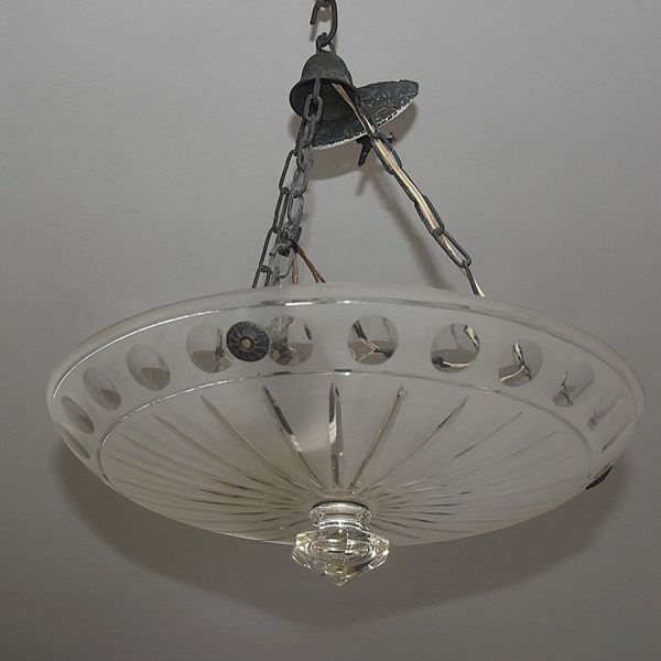 Plafonnier em vidro fosco de linhas Art Déco, com cúpula em formato de tigela invertida, borda vazada com recortes ovais e corpo central com nervuras em relevo irradiadas em efeito de leque/estrela. É