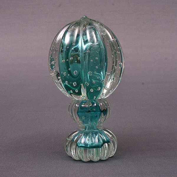 Pinha decorativa em vidro artístico de Murano, em tonalidade azul-esverdeado translúcida, moldada em forma estilizada de fruto, com gomos verticais em relevo e decoração interna por bolhas de ar contr