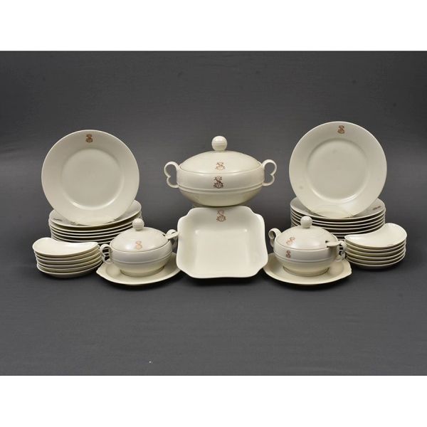 Aparelho de porcelana tcheca com monograma em dourado. Composto de 61 pratos rasos, 31 fundos, 13 de apoio, 60 de sobremesa, 32 de entrada, 3 travessas ovais, 1 sopeira, 1 saladeira, 2 nolheiras com p
