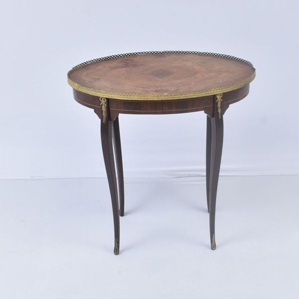 Mesa francesa estilo Luís XV, tampo oval em marchetaria com motivos florais e geométricos, emoldurado por galeria vazada em bronze dourado. Pernas cabriolé finas e curvas, com friso de filete claro no