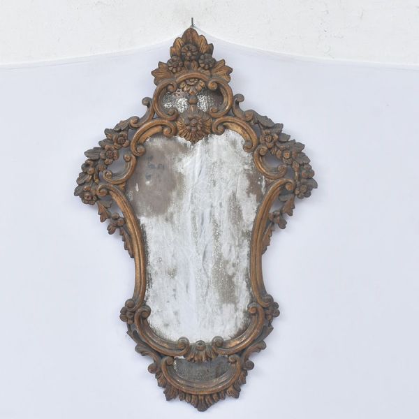 Espelho de parede estilo francês Louis XV com moldura em madeira ricamente entalhada e patinada em dourado envelhecido, apresentando exuberante decoração em volutas, concheados, flores e folhagens em