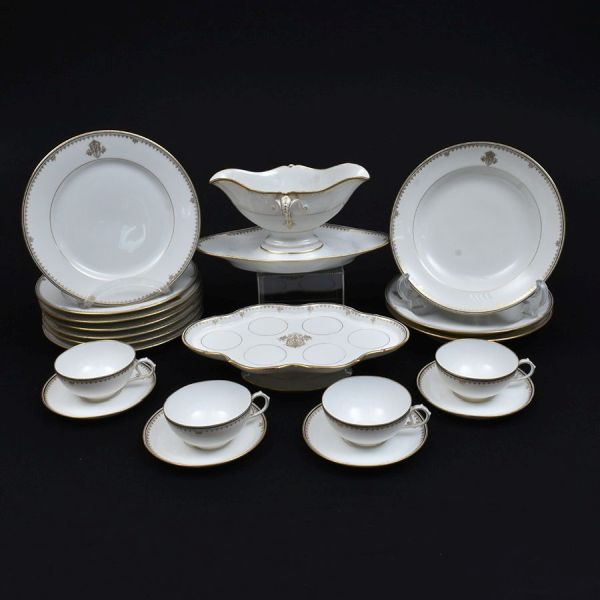 Aparelho brasonado de porcelana francesa do sec. XIX `Charles Pillivuyt & Cie`. Decoração em elegante friso dourado intercalando com friso em azul e brasão na borda. Composto de 7 pratos rasos, 3 fund