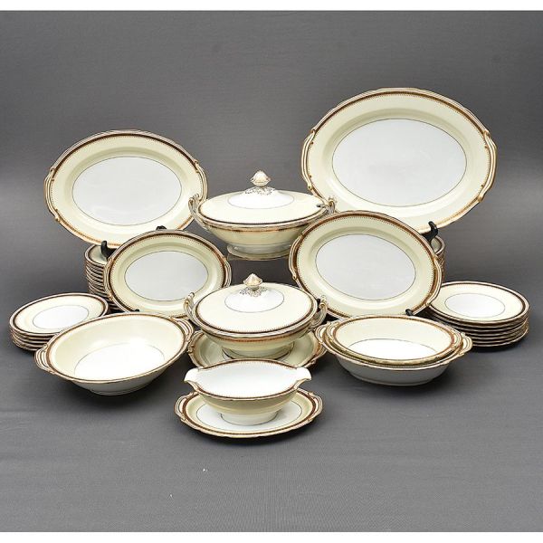 Aparelho de jantar de porcelana japonesa Noritake, na cor creme com frisos dourados. Composto de 24 pratos rasos, 12 fundos, 12 de sobremesa, 1 sopeira, 1 legumeira, 6 travessas ovais, 1 saladeira, 1
