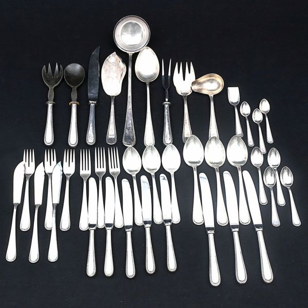 Faqueiro Wolff com perolado na borda. Composto de 12 facas e 8 garfos de carne, 12 facas e 12 garfos de peixe, 12 facas e 12 garfos de sobremesa, 10 colheres de sopa, 10 de sobremesa, 12 de chá, 10 de