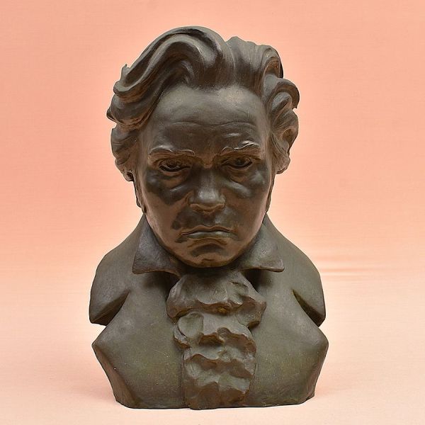 Busto do compositor Ludwig van Beethoven, produzido por ocasião do centenário de sua morte (1827–1927). Busto em bronze, ricamente detalhado, com expressão intensa e vestes clássicas. No verso assinat
