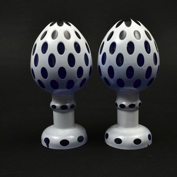 Par de pinhas francesas em cristal azul-cobalto apresentando corpo ovóide estilizado sobre base torneada. Decoradas em técnica de sobreposição (overlay) em branco. Alt. 22 cm. Mínimo bicadinho na base