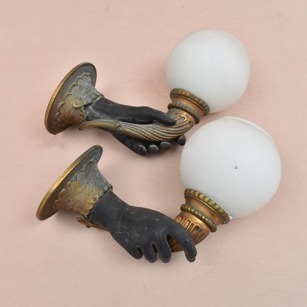 Par de apliques de parede em bronze patinado estilo Império/Napoleão III,, com fuste em forma de mão emergente de punho entalhado com babados, sustentando globo em vidro opalino esférico. Alt. 25 cm e