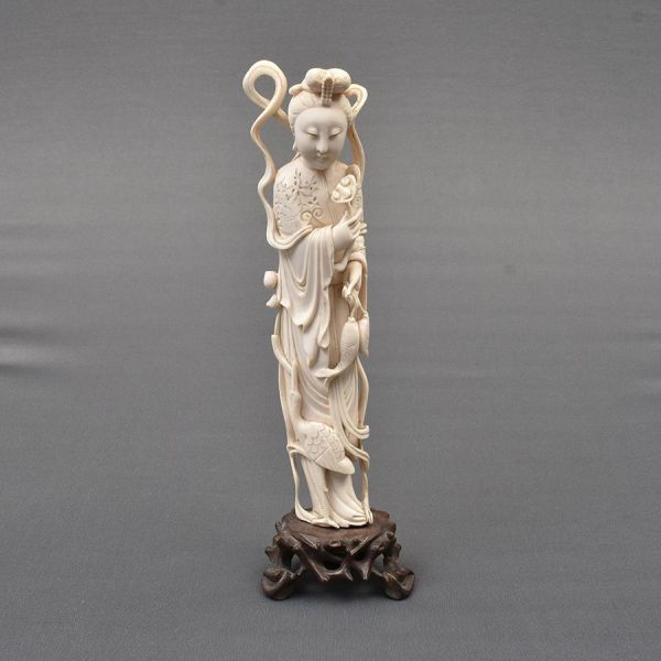 Escultura de marfim chinês cerca de 1940 representando LAN TSAI HO. Deusa imortal chinesa conhecida como "Deusa dos Jardins". Veste adornada por flores. Segura seu tradicional cesto de floral. Alt. to