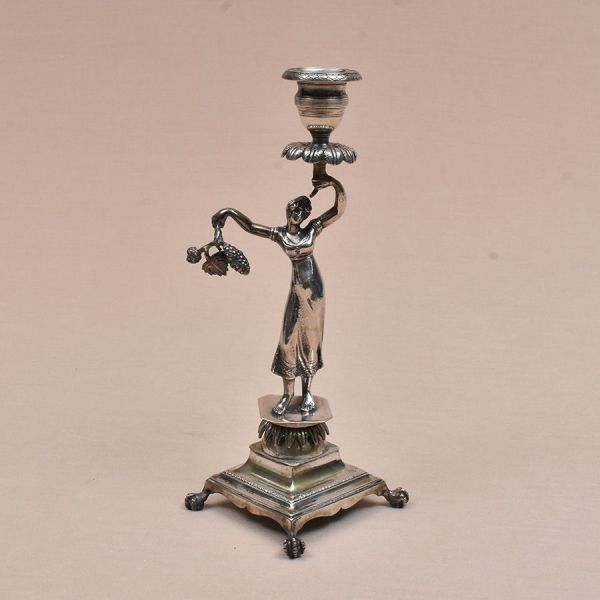 Paliteiro português de prata do sec. XIX, contraste Coroa e marca do ourives. Representa figura de mulher com flores e frutos e segura uma cornucópia. Base quadrangular e pés de garra. Alt. 26 cm. Pes