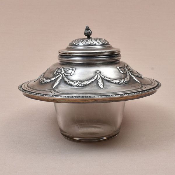 Bomboniere de prata francesa contraste cabeça de Mercúrio. Decoração cinzelada com laço de fitas e borda com folhagens de louros. Recipiente de cristal liso. Alt. 18 cm e ddiam. Ext 22 cm. Peso bruto