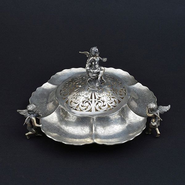 Centro de mesa bomboniere de prata portuguesa contraste Águia com punção de garantia de teor 833 milésimos. Formato circular adornado com figuras angelicais em relevo. Diam. 33 cm. Peso: 2.270g