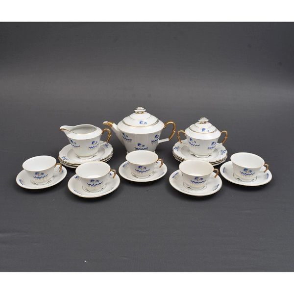 Aparelho de chá de porcelana tcheca na cor branca com detalhes decorativos em azul. Composto de bule de chá, leiteira, açucareiro, 5 xícaras com pires e 6 pratinhos para bolo. Total 19 peças