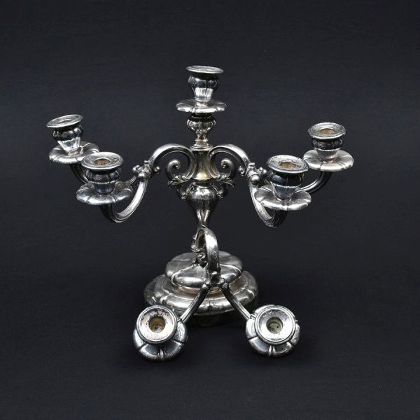 Candelabro de prata austro-húngara para 7 velas com punção de garantia de teor 800 milésimos. Trabalhado em gomos. Necessita solta em uma dupla de braços. Alt. 35 cm. Peso da prata 1.380g.