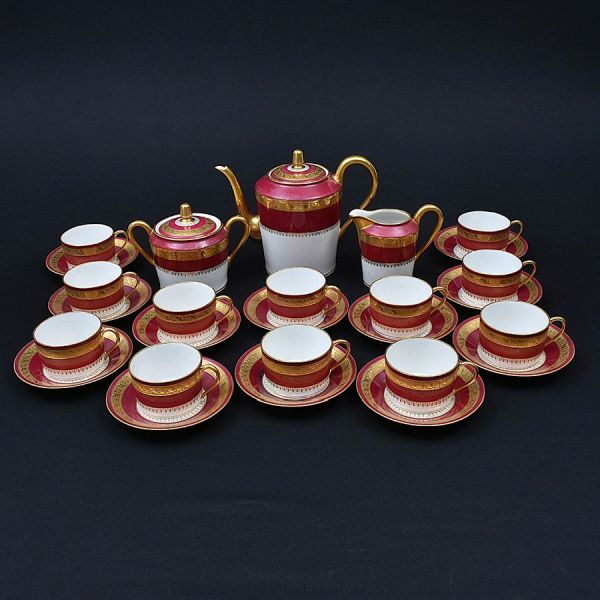 Aparelho de chá de porcelana francesa de Limoges na cor vinho branco com arabescos dourados. Composto de bule de chá, leiteira, açucareiro e 12 xícaras com pires. Total 27 peças