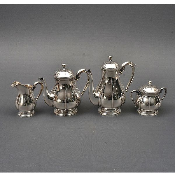Aparelho de prata alemã com punção de garantia de teor 800 milésimos. Composto de bules de chá e café, leiteira e açucareiro. Alt. bule maior. 24 cm. Peso: 1.440g.