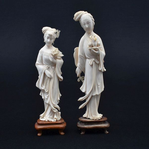 Par de estatuetas de marfim chinês cerca de 1940 representado figuras de damas. Base de madeira. Alt. total 20 e 17 cm. Imperceptivel bicado na folha da bandeja.