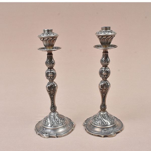 Par de castiçais de prata peruana Sterling prateiro Camusso, com punção de garantia de teor 925 milésimos. Todo cinzelado com acantos. Alt. 29 cm. Peso: 800g.