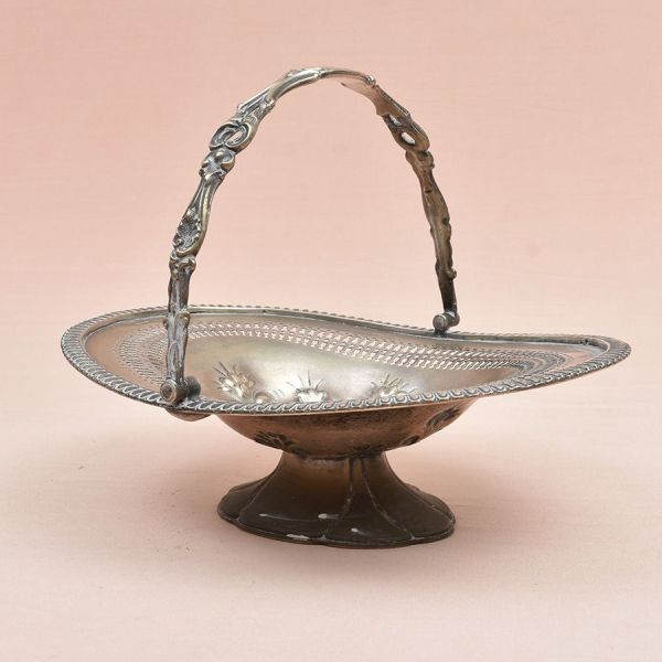 Cesta europeia prateada de formato ovalado com delicado cinzel floral ao centro e decoração em vasados na borda. Med. 25 (com alça) x 31 x 25 cm (A x L x P)
