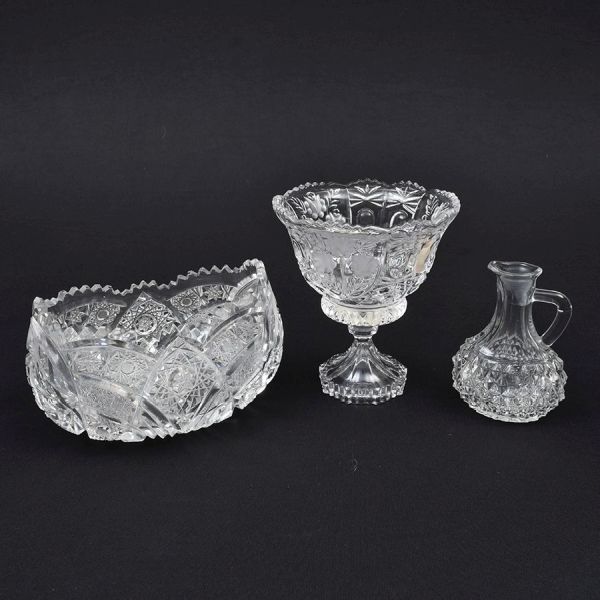 Três peças: Bombonire, jarrinha para molho e bowl ovalado. Todas as peças ricamente lapidadas. Alt. 16, 12 e 12 cm. O bowl apresenta dois bicados na borda