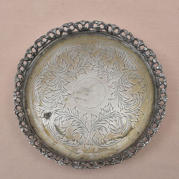 Salva de prata brasileira, prateiro Michel Kouri com punção de garantia de teor 800 milésimos. Decoração com acantos e volutas. Diam. 18 cm. Peso: 365g.