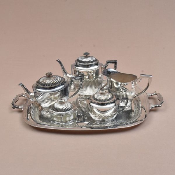 Eberle. Aparelho de chá e café cinzelado em gomos. Composto de bandeja, bules de chá e café, leiteira, açucareiro e cremeira. Med. bandeja 60 x 38 cm.