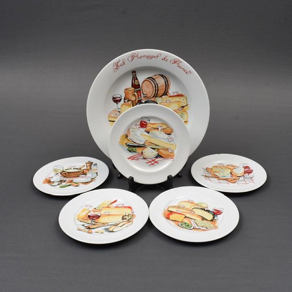 Conjunto de porcelana para queijos com uma travessa redonda e 5 pratinhos . Decoração característica. Diam. 32 e 20 cm. Um dos pratinhos com bicado.