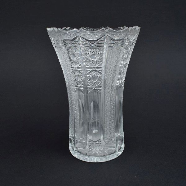 Vaso de cristal europeu com lapidação geométrica preenchendo todo o bojo. Borda ondulada. Alt. 30 cm e diam. 20 cm. Pequeno bocadinho na borda.