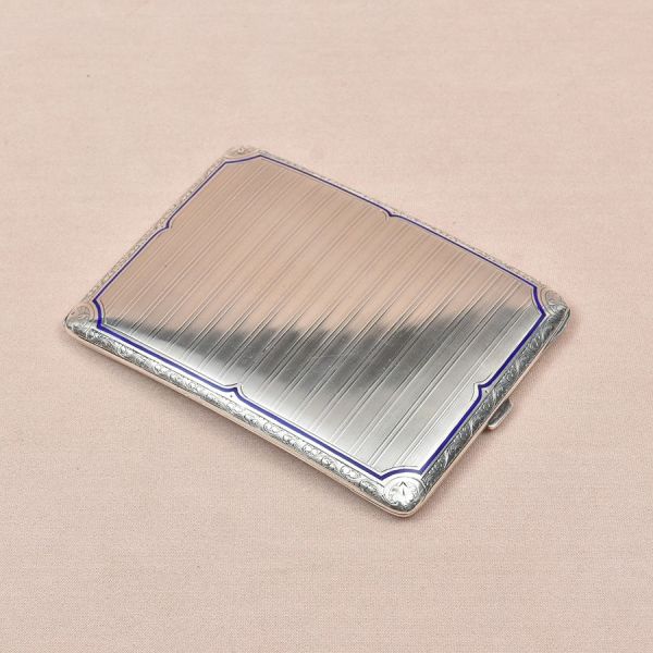 Cigarreira de prata alemã contrastada com punção de garantia de teor 900 milésimos. Decoração em frisos lavrados. Med. 12 x 10 cm. Peso: 180g.