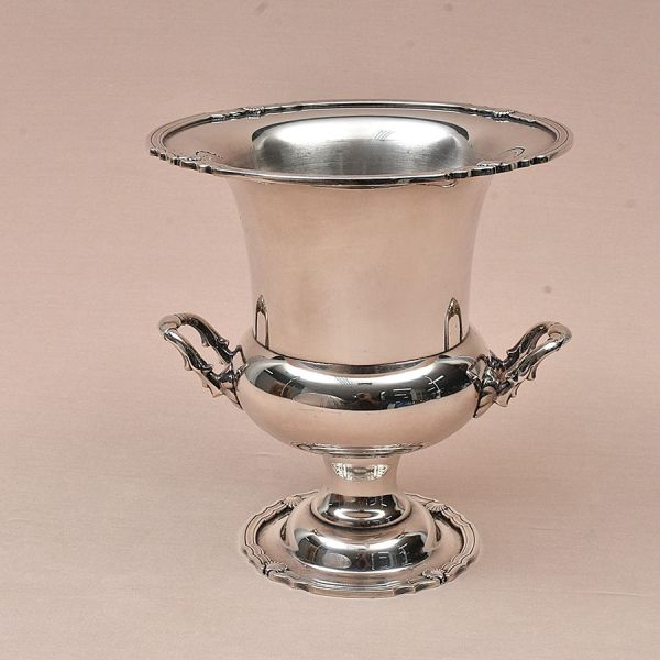 Eberle. Champanheira prateada e elegantemente lisa. Alças com trabalho em motivos vegetativos de acantos. Alt. 25,5 cm e diam. ext. 24 cm.