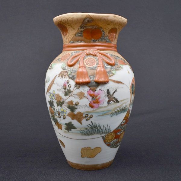 Vaso de porcelana chinesa decorada com flores em policromia e douração e arrematado com laço de fita em relevo em tom laranja. Alt. 24 cm.