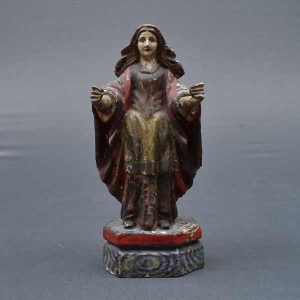 Bahia – sec. XIX. Imagem de madeira representando Nossa Senhora do Rosário. Veste em tons de ocre e vermelho. Base chanfrada. Alt. 23 cm.