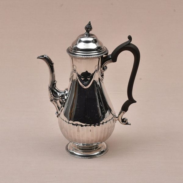 Bule de café de prata inglesa, contraste de Londres, ano de 1902. Bojo liso com delicada guirlanda. Alça de madeira. Peso bruto 705g.