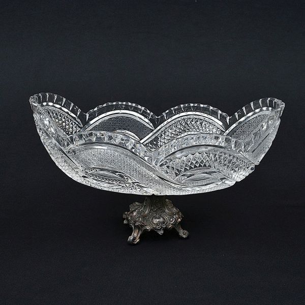 Centro de mesa de cristal ricamente lapidado em elementos geométricos e base em pewter cinzelado. Med. 18 x 31 x 17 cm (A x L x P)