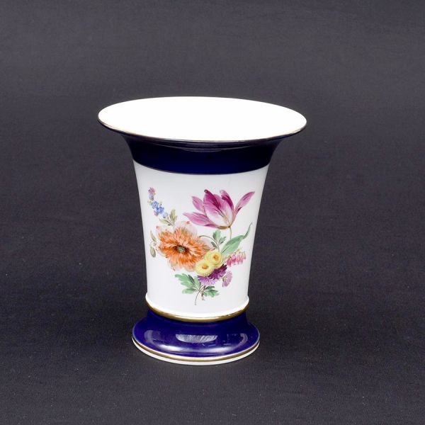 Meissen. Vaso de porcelana alemã decoração floral em policromia com borda e base em azul royal com filete a ouro. Alt. 20 cm.