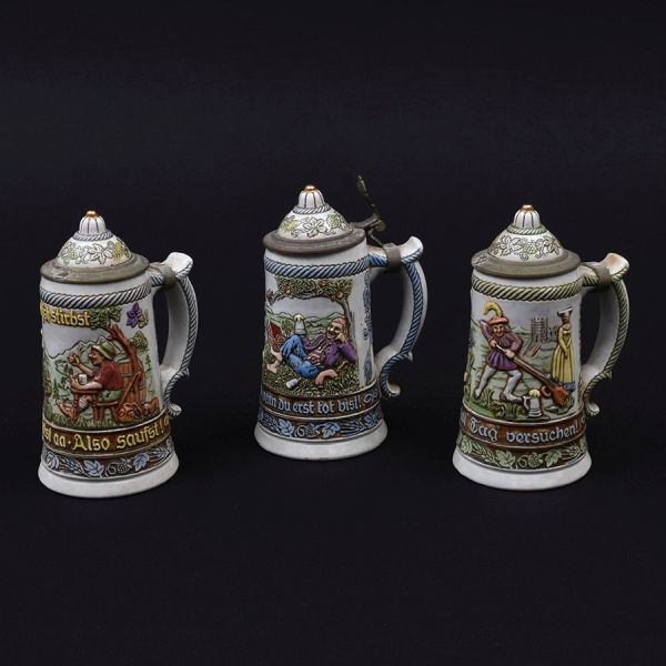 Conjunto de três canecas holandesas de faiança de diferentes decorações com tampas de pewter (necessitam solda). Alt. 22 cm.