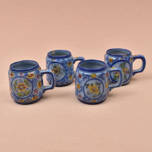 Quatro canecas de faiança portuguesa de Coimbra na cor azul com flores em policromia. Duas delas com bicadinhos. Alt. 11 cm.