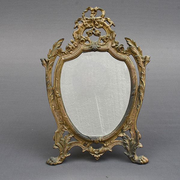 Espelho de mesa francês em bronze dourado todo cinzelado no estilo Louis XV com flores e laços de fitas. Med. 40 x 26 cm.