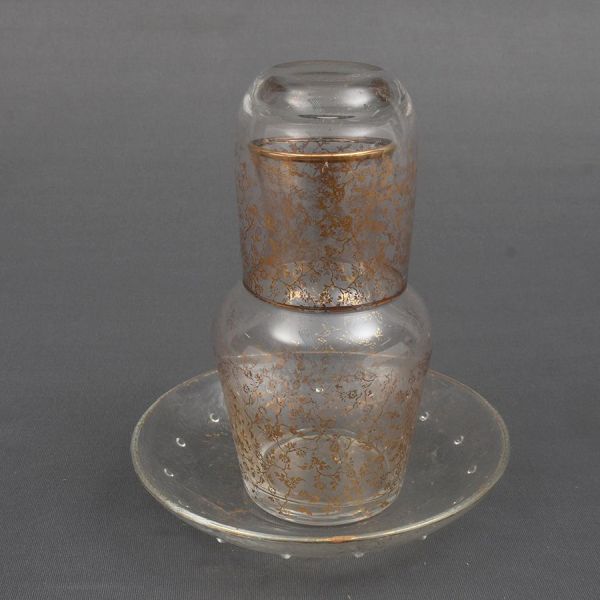 Moringa com copo e presentoir de cristal francês translúcido decorado com delicadas flores no padrão dourado. Alt. 21 cm.