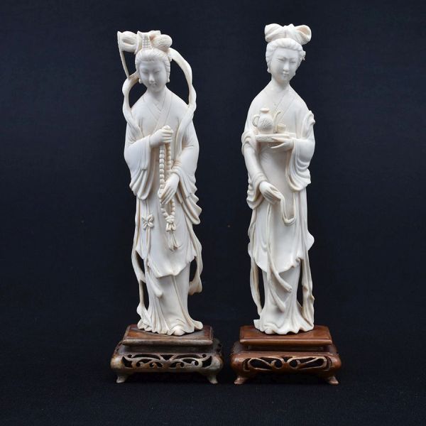 Par de estatuetas de marfim chinês cerca de 1940 representado figuras de damas. Base de madeira. Alt. total 21 e 20 cm.