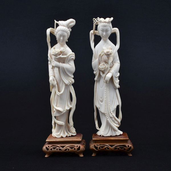 Par de estatuetas de marfim chinês cerca de 1940 representado figuras de damas. Base de madeira. Alt. total 20 cm.
