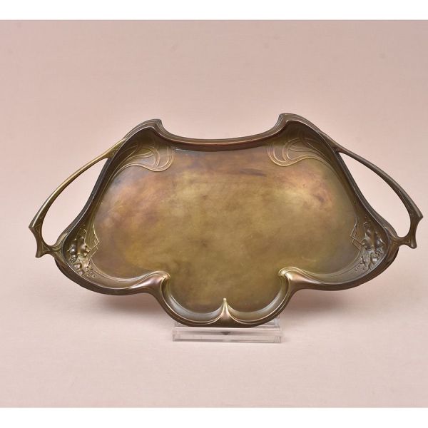 Bandeja Art Nouvau em metal dourado sinuosa e decorada com elementos característicos do estilo. Med. 63 x 33 cm.